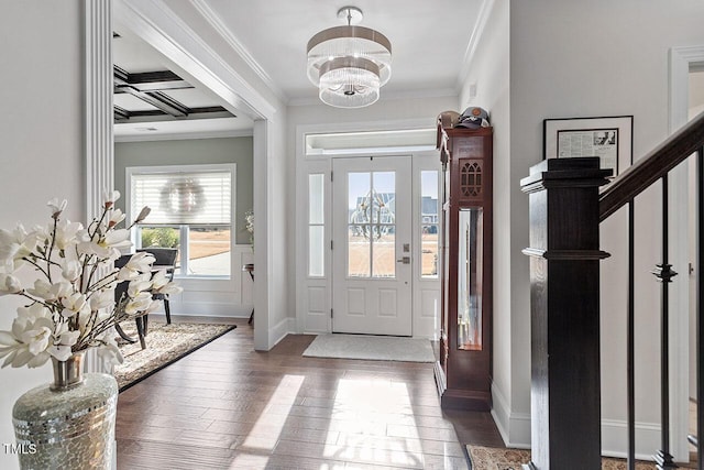 foyer featuring wood-type flooring, an inviting chandelier, and ornamental molding