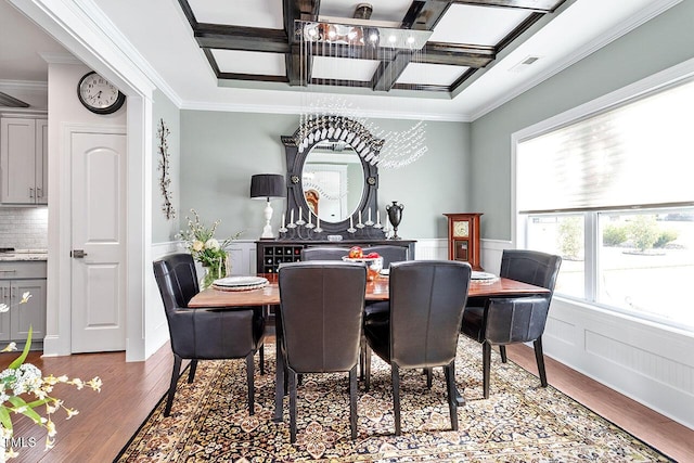 dining room featuring crown molding, a chandelier, and hardwood / wood-style flooring