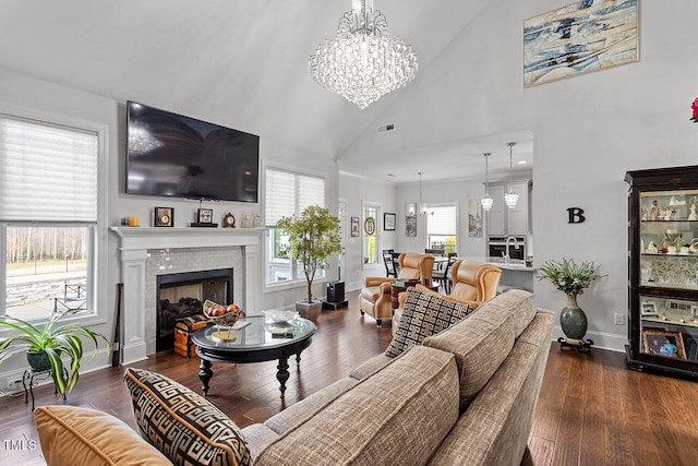 living room featuring high vaulted ceiling, a chandelier, and dark hardwood / wood-style floors