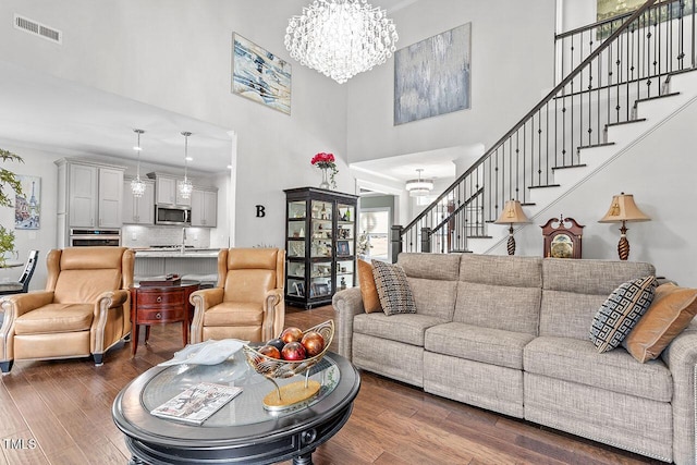 living room featuring dark hardwood / wood-style flooring, a high ceiling, and a chandelier