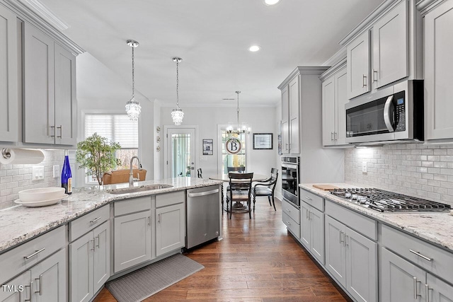 kitchen featuring gray cabinetry, sink, hanging light fixtures, decorative backsplash, and stainless steel appliances