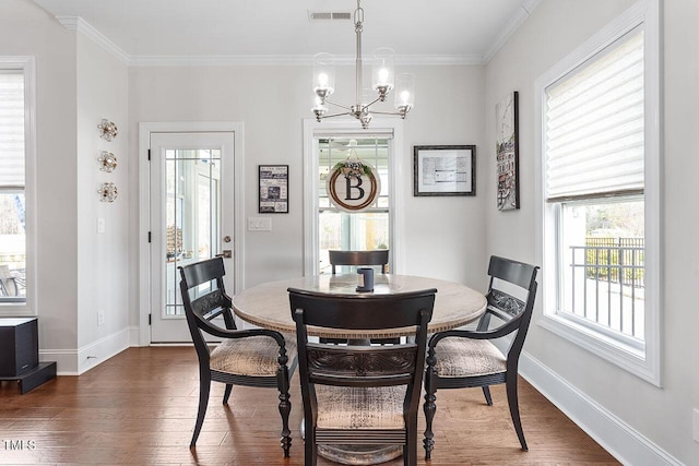 dining space featuring a notable chandelier, dark hardwood / wood-style flooring, and ornamental molding