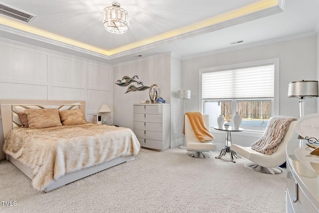 bedroom with carpet, a tray ceiling, ornamental molding, and a notable chandelier