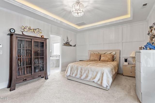 carpeted bedroom featuring ensuite bathroom, white refrigerator, ornamental molding, a tray ceiling, and a chandelier