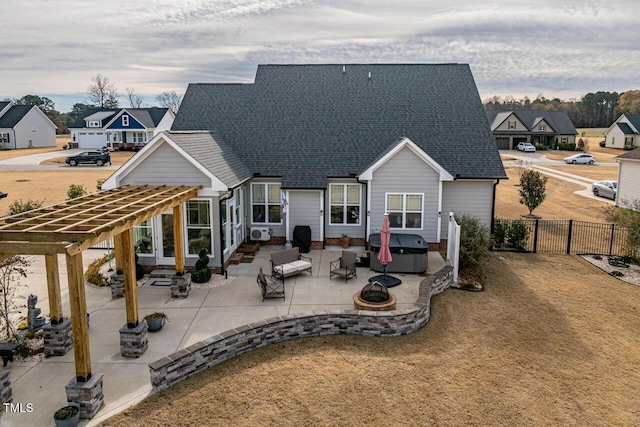 rear view of property with a fire pit, a pergola, and a patio