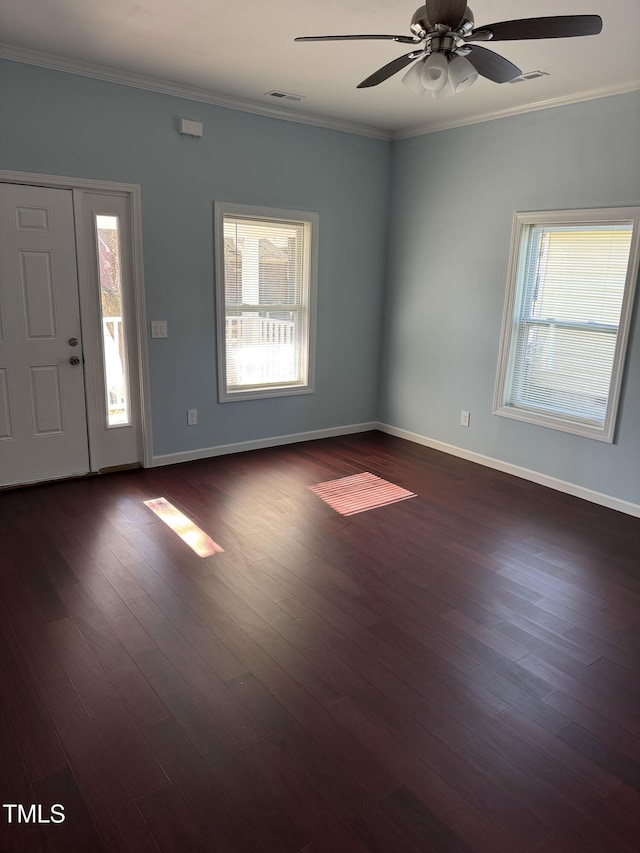 foyer entrance featuring ornamental molding, dark wood-type flooring, and a healthy amount of sunlight