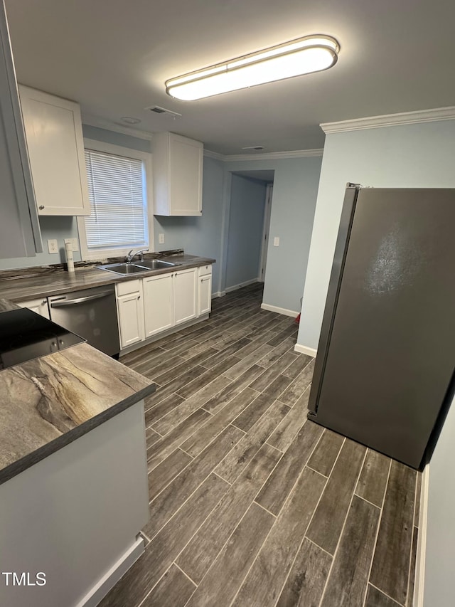 kitchen with wood finish floors, dark countertops, freestanding refrigerator, white cabinetry, and dishwasher