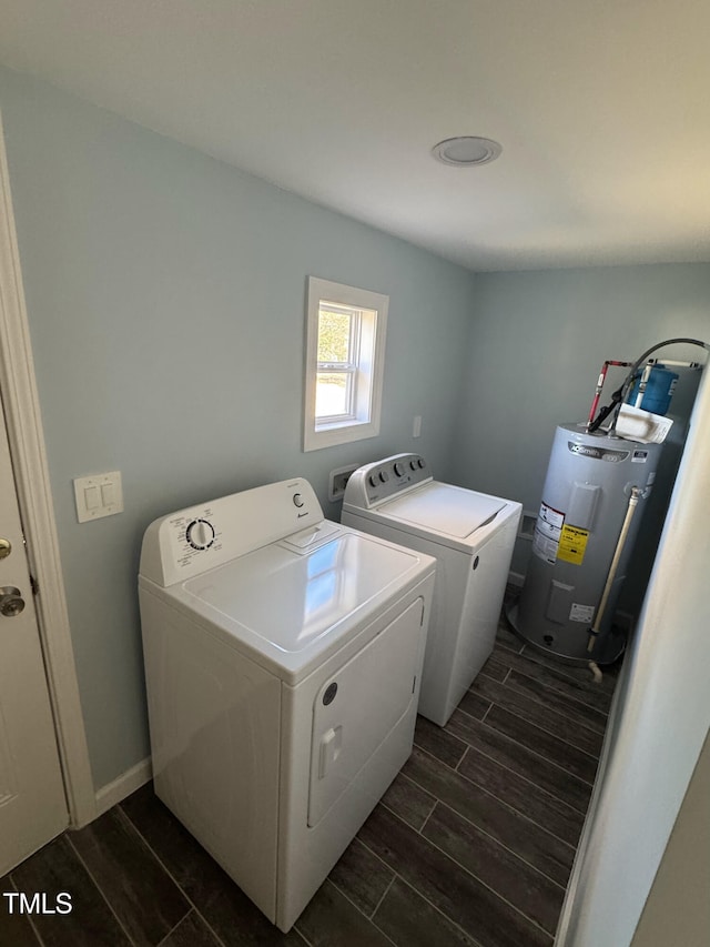 laundry area featuring laundry area, baseboards, wood finish floors, water heater, and separate washer and dryer