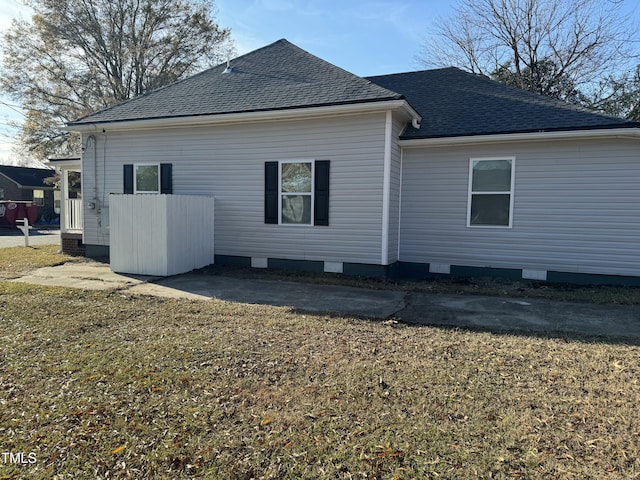 rear view of house featuring crawl space, roof with shingles, and a yard