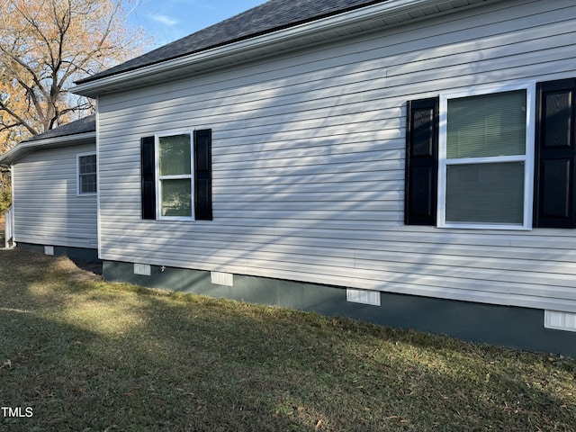 view of home's exterior featuring a shingled roof, crawl space, and a yard