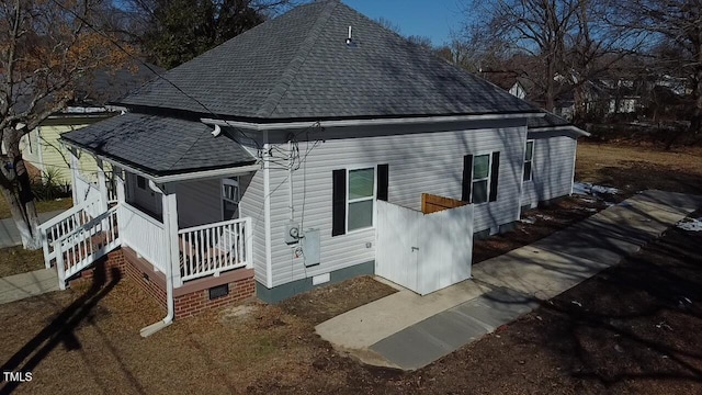 exterior space featuring roof with shingles and crawl space