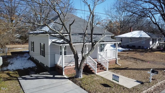 view of front of house featuring covered porch and a shingled roof