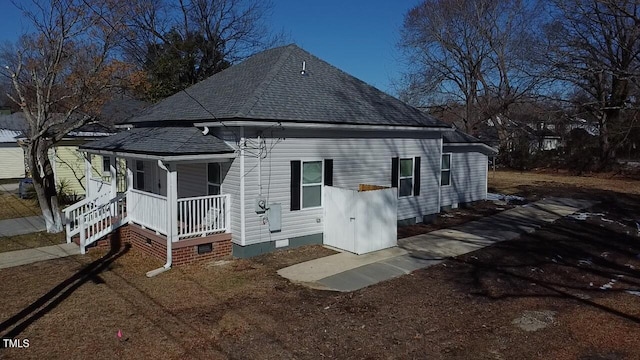 rear view of property with a shingled roof and crawl space