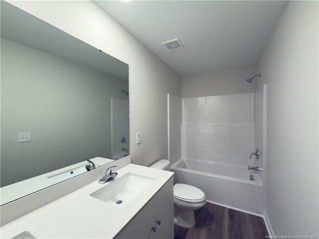 full bath with visible vents, shower / bathing tub combination, toilet, vanity, and wood finished floors