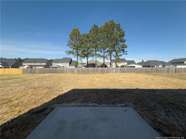 view of yard with a patio area, a fenced backyard, and a residential view