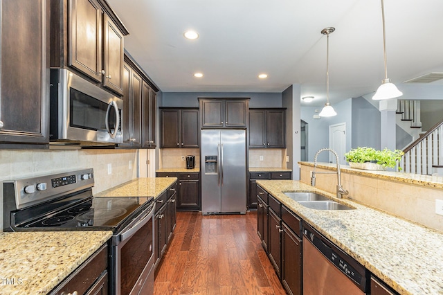 kitchen with dark hardwood / wood-style flooring, dark brown cabinets, stainless steel appliances, sink, and pendant lighting