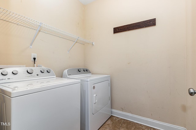 washroom with separate washer and dryer and dark tile patterned flooring