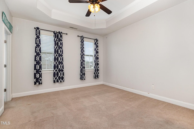 carpeted empty room featuring a tray ceiling, ceiling fan, and ornamental molding