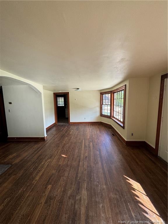 unfurnished living room with dark hardwood / wood-style flooring