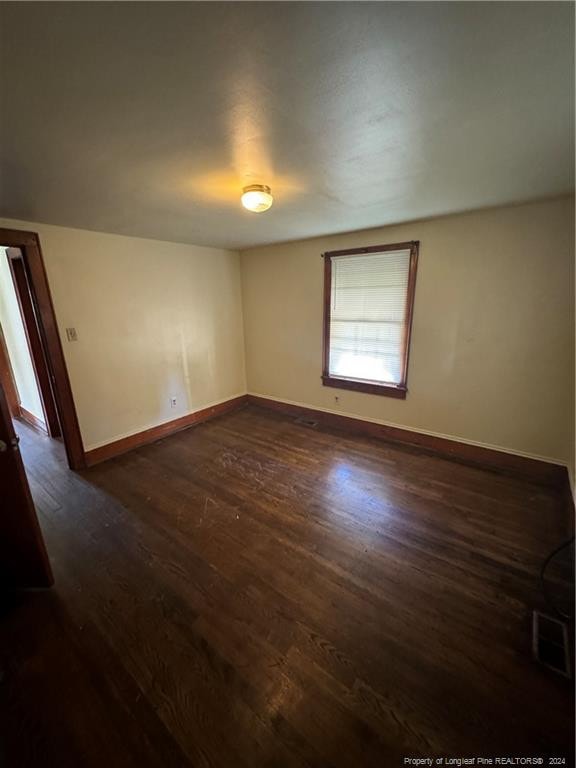 spare room with dark wood-type flooring