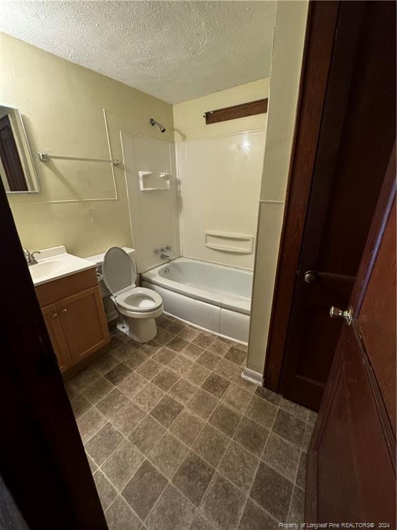 full bathroom with vanity, a textured ceiling, toilet, and shower / bathtub combination