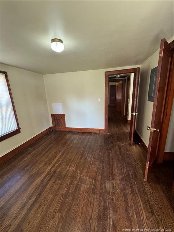 unfurnished room with dark wood-type flooring