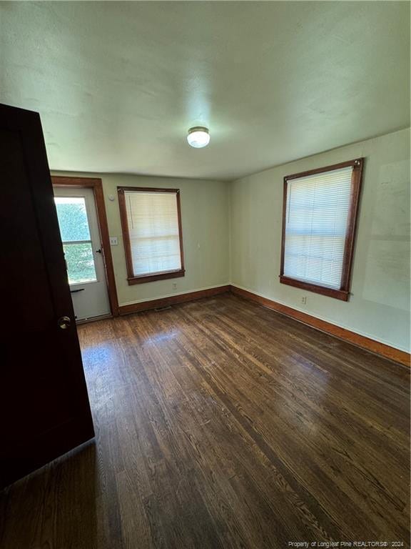 unfurnished room with dark hardwood / wood-style floors