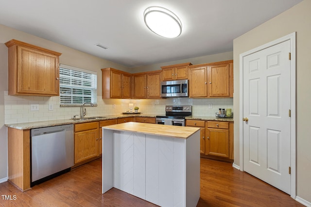 kitchen with dark wood-style flooring, tasteful backsplash, visible vents, appliances with stainless steel finishes, and a sink