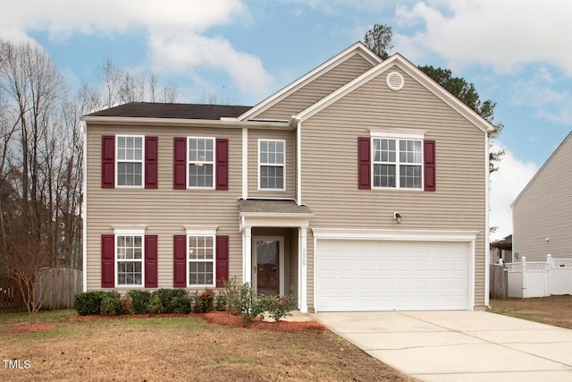 traditional home featuring a front yard, fence, driveway, and an attached garage