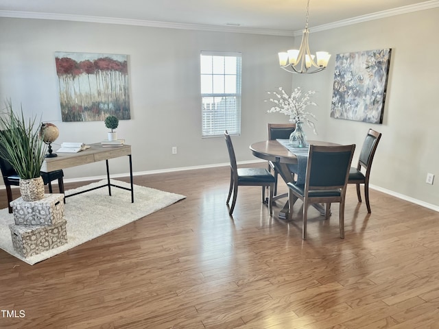 dining room with baseboards, crown molding, an inviting chandelier, and wood finished floors