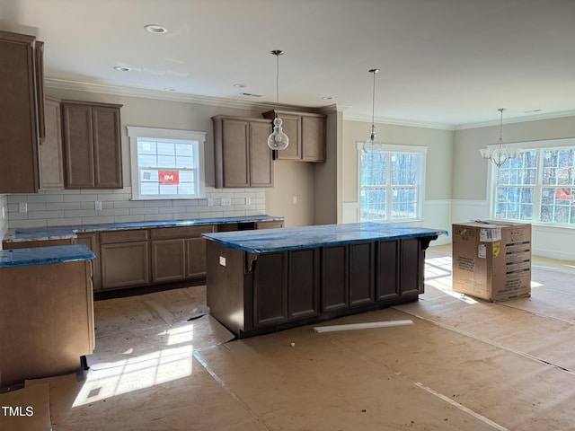 kitchen featuring pendant lighting, tasteful backsplash, a center island, and plenty of natural light