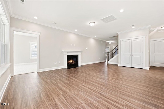 1975 Meadowview Dr, Graham, NC 27253 - unfurnished living room with a fireplace with flush hearth, stairs, light wood-type flooring, and baseboards
