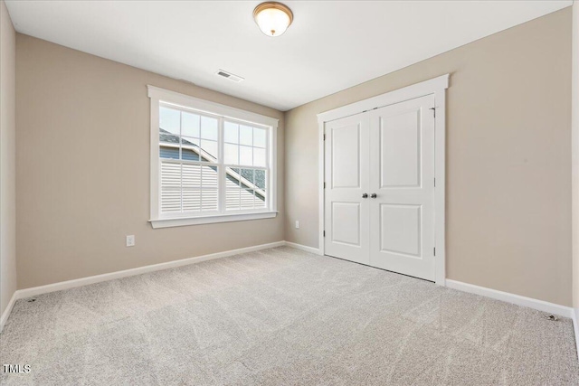 1975 Meadowview Dr, Graham, NC 27253 - unfurnished bedroom featuring baseboards, visible vents, a closet, and carpet floors