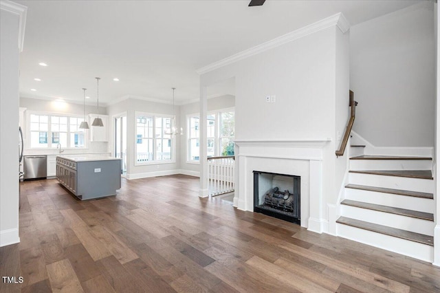 unfurnished living room with plenty of natural light, dark hardwood / wood-style flooring, and crown molding