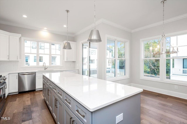 kitchen featuring sink, a center island, dark wood-type flooring, tasteful backsplash, and appliances with stainless steel finishes