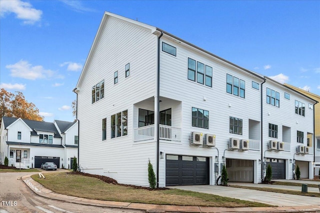 view of front facade with a wall mounted AC and a balcony