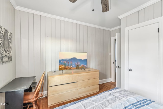 bedroom with crown molding, ceiling fan, dark wood-type flooring, and wood walls