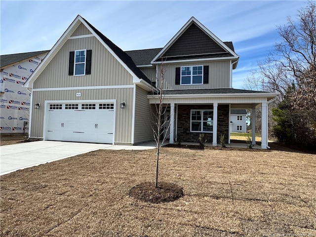 view of front of home with a porch, a garage, concrete driveway, stone siding, and board and batten siding