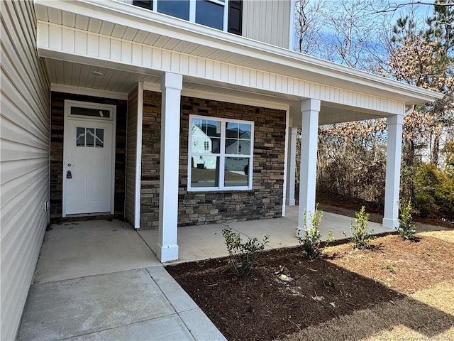 entrance to property featuring stone siding and a porch