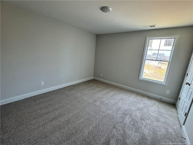 carpeted empty room with visible vents and baseboards