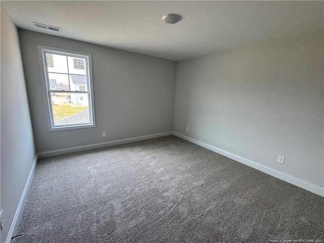 carpeted spare room featuring baseboards and visible vents