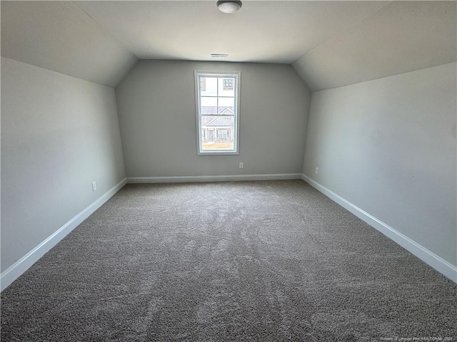 additional living space featuring vaulted ceiling and baseboards