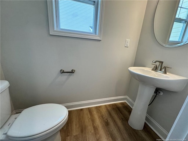 bathroom with toilet, wood finished floors, and baseboards