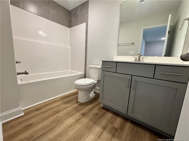 bathroom with vanity, baseboards, shower / tub combination, toilet, and wood finished floors