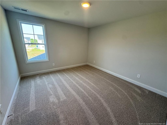 carpeted spare room featuring visible vents and baseboards
