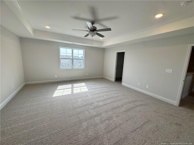 unfurnished room featuring baseboards, ceiling fan, carpet, crown molding, and a tray ceiling