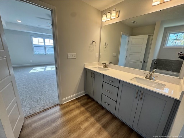 bathroom featuring a sink, baseboards, and double vanity