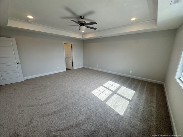 carpeted empty room featuring ceiling fan, baseboards, ornamental molding, and a raised ceiling