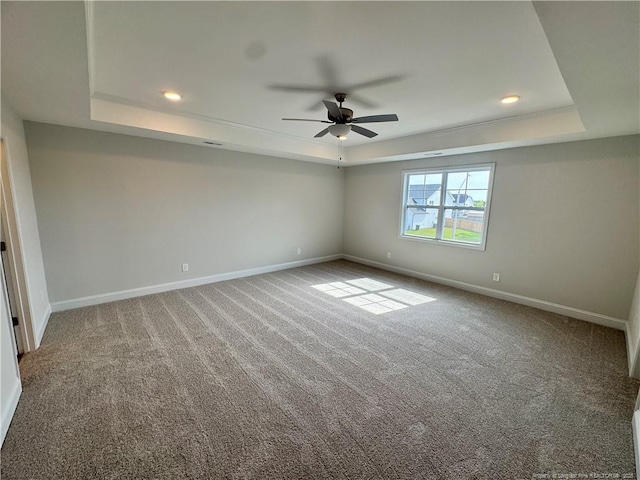 carpeted spare room featuring recessed lighting, ceiling fan, baseboards, and a raised ceiling