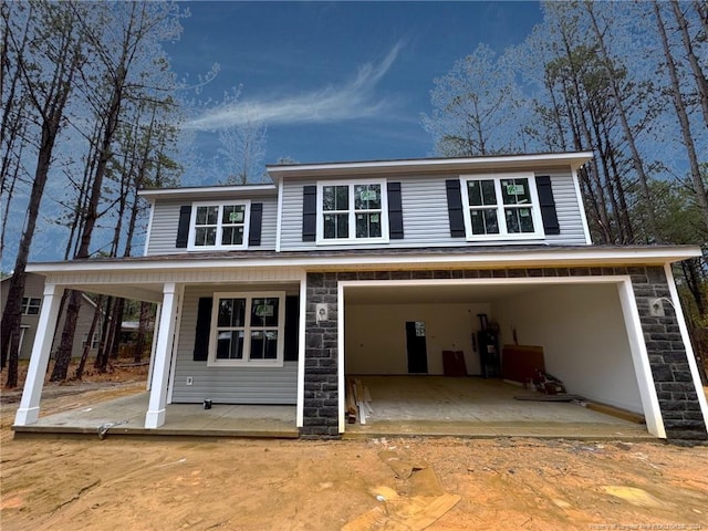 rear view of house with a garage and a porch